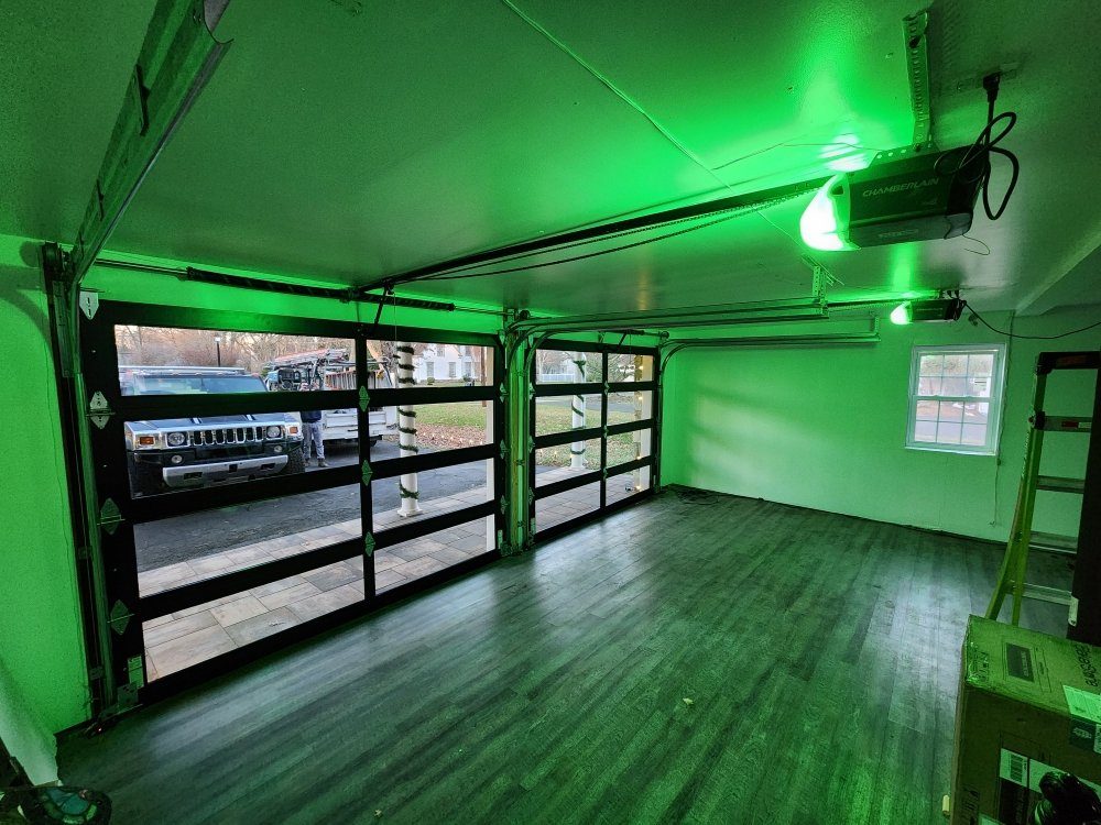 Interior view of two full-view aluminum and glass garage doors with a ceiling-mounted opener